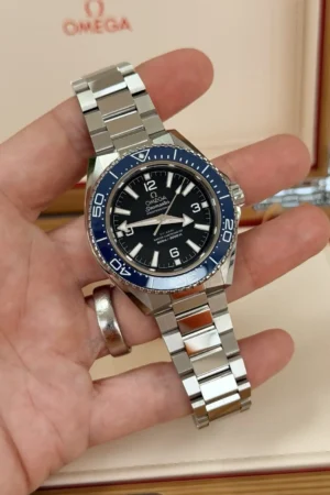 Omega Planet Ocean 42 mm à lunette bleue (2025), avec bracelet Omega et bracelet en caoutchouc.